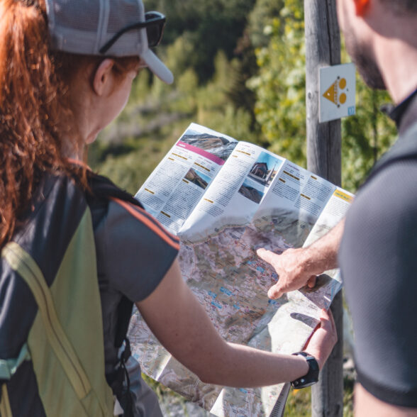 Photo d'un homme et une femme de dors en train de consulter un plan des randonnées du Corbier
